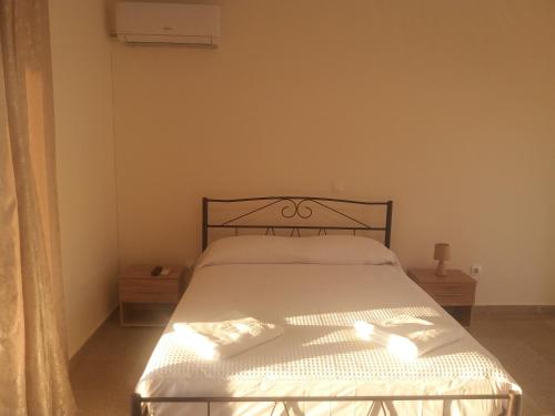 a bedroom with a bed with white sheets and a window at Nereids Apartments-Galene in Petalidhion