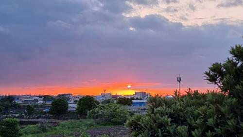 - un coucher de soleil sur une ville dans l'établissement Stay be oom, à Jeju