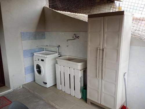a bathroom with a washing machine and a washer at CasaFigus La Terrazza NARBOLIA in Narbolia