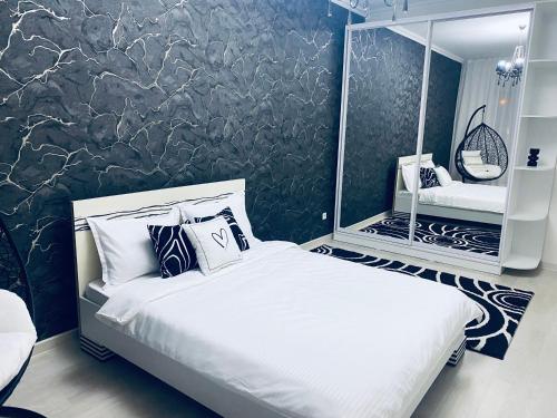 1 dormitorio con cama blanca y pared negra en Like Home Hostel na Shevchenko, 162Б en Almaty