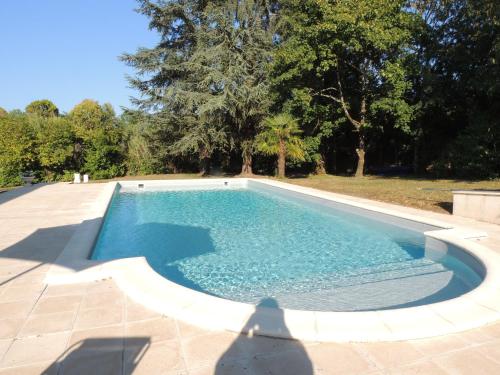 una piscina de agua azul en un patio en LE JARDIN D AURELIE en Sainte-Livrade-sur-Lot