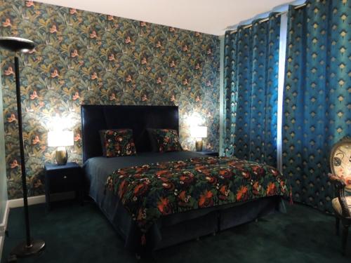 um quarto com uma cama com papel de parede floral em LE JARDIN D AURELIE em Sainte-Livrade-sur-Lot