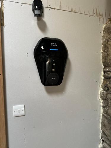 a black object is hanging on a wall at Ty Hapus Central Beaumaris in Beaumaris