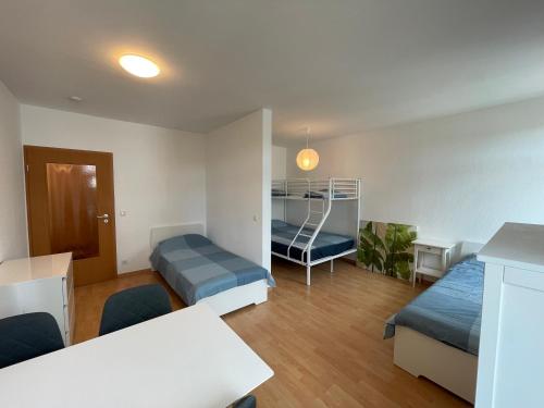 ein Zimmer mit zwei Betten und einem Schreibtisch und einem Tisch in der Unterkunft Wohnglück Dresden in Dresden