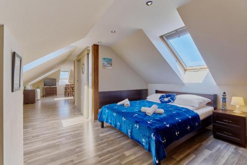 sypialnia z łóżkiem z niebieską pościelą i oknem w obiekcie Villa Konwalia w Grzybowie
