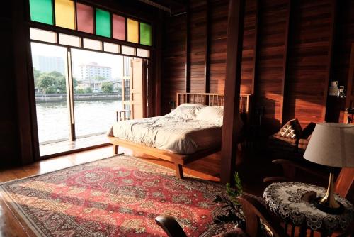 a bedroom with a bed in a room with a window at Bannai Bangkoknoi บ้านในบางกอกน้อย in Ban Bang Bamru