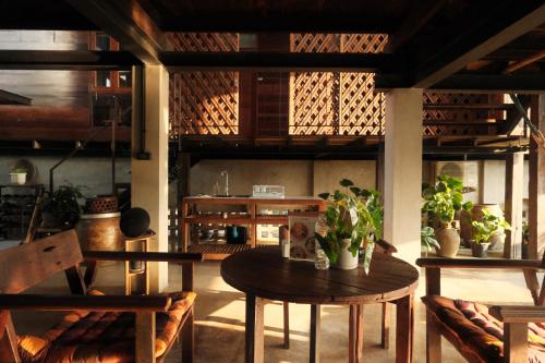 a room with a table and chairs and a kitchen at Bannai Bangkoknoi บ้านในบางกอกน้อย in Ban Bang Bamru