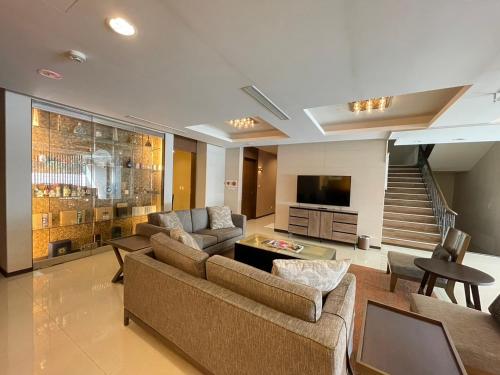 a living room with two couches and a television at Great Roots Forestry Spa Resort in Sanxia