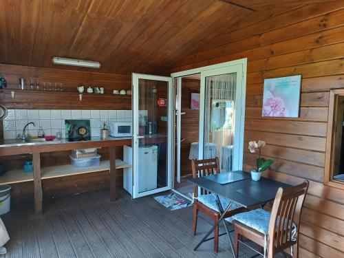 a dining room with a table and a kitchen at Le Clos des Mimosas in La Plaine des Palmistes