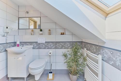 ein weißes Badezimmer mit Toilette und Waschbecken in der Unterkunft Villa Konwalia in Grzybowo