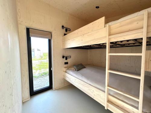 Zimmer mit Etagenbetten und Fenster in der Unterkunft Hello Zeeland - Tiny House Zeeuwse Liefde 5 in Westkapelle