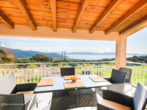 une terrasse avec une table et des chaises ainsi qu'une grande fenêtre. dans l'établissement A CASA DI PAULINA, à Serra-di-Ferro