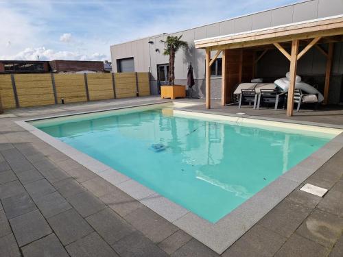 a large blue swimming pool with a pavilion at Klein duimpje in Echt