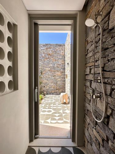a bathroom with a glass door leading to a patio at Egeo Paros in Kampos Paros