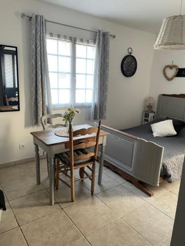 une salle à manger avec une table et un lit dans l'établissement Maison d'hôtes L'air d'antan, à Bias
