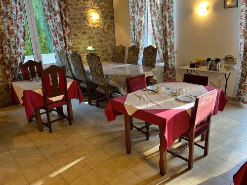 een eetkamer met tafels en stoelen met rode servetten bij Château Lou Cante Perdrix in La Vernarède