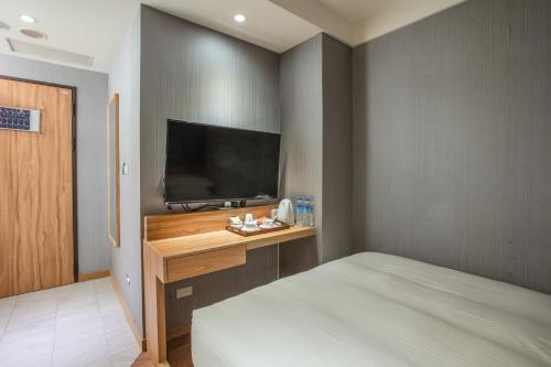 a bedroom with a bed and a flat screen tv at 雲富大飯店 Hotel Cloud-ZhongShan in Taipei