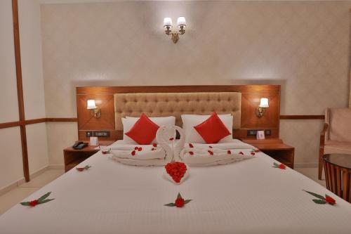 a bedroom with a large white bed with red pillows at Lagoona Beach Resort in Kovalam