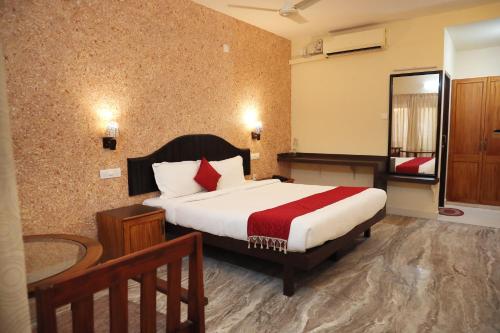 Habitación de hotel con cama y espejo en Lagoona Beach Resort, en Kovalam