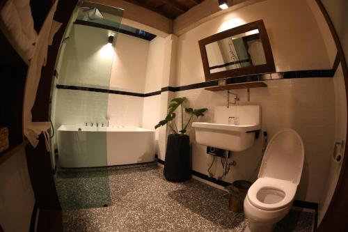a bathroom with a sink and a toilet and a tub at Baanrongmai Canal Front Cafe & Homestay in Bang Chak