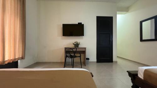 a bedroom with a bed and a desk and a television at HOTEL CATALUÑA - SOLUCIONES HOTELERAs in Pereira