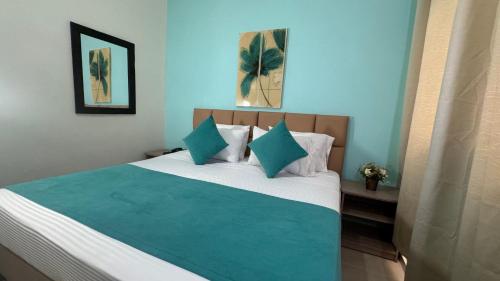 a bedroom with a blue and white bed with pillows at HOTEL CATALUÑA - SOLUCIONES HOTELERAs in Pereira