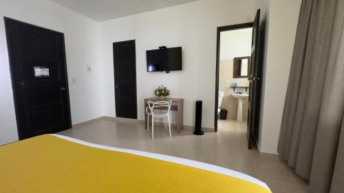 a bedroom with a bed and a table and a mirror at HOTEL CATALUÑA - SOLUCIONES HOTELERAs in Pereira