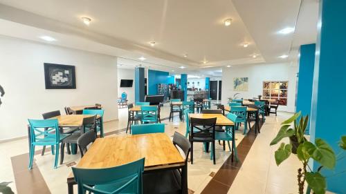 un comedor con sillas y mesas azules en HOTEL CATALUÑA - SOLUCIONES HOTELERAs en Pereira