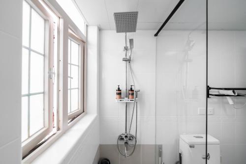 a white bathroom with a shower and a toilet at Shanghai Yi Du B&B -Family - Friendly Suite Close to People's Square and Subway in Shanghai
