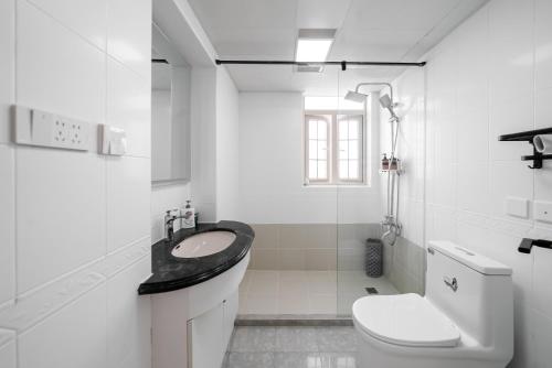 a white bathroom with a sink and a toilet at Shanghai Yi Du B&B -Family - Friendly Suite Close to People's Square and Subway in Shanghai