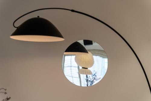 a mirror hanging on a wall with a lamp and mushrooms at Shanghai Yi Du B&B -Family - Friendly Suite Close to People's Square and Subway in Shanghai