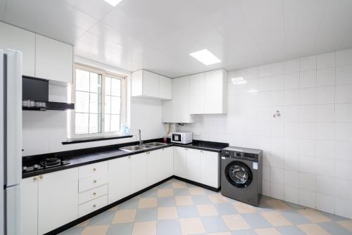 a white kitchen with a washing machine in it at Shanghai Yi Du B&B -Family - Friendly Suite Close to People's Square and Subway in Shanghai