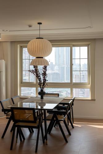 a dining room with a table and chairs and a chandelier at Shanghai Yi Du B&B -Family - Friendly Suite Close to People's Square and Subway in Shanghai