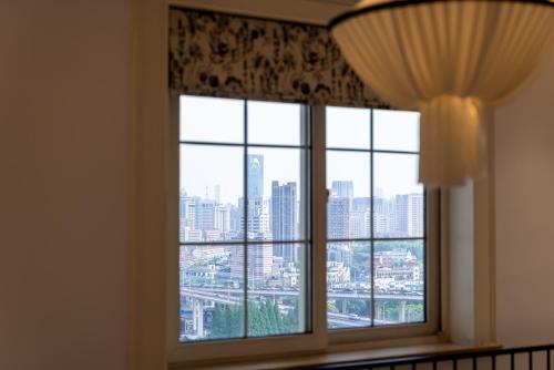 a window with a view of a city at Shanghai Yi Du B&B -Family - Friendly Suite Close to People's Square and Subway in Shanghai
