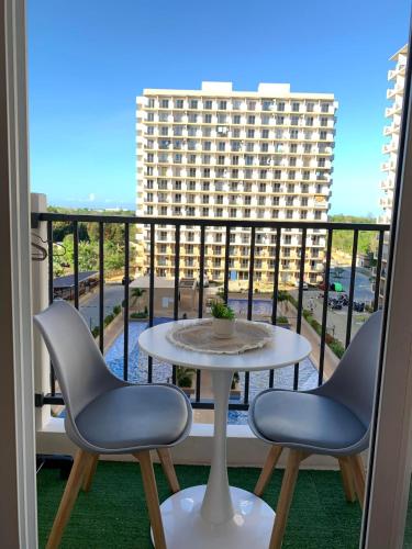 Un balcón con una mesa y sillas y un edificio. en Vee Sky Hideaway, en Suba