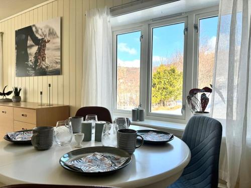 a dining room table with plates and glasses on it at A pearl in Lofoten in Leknes