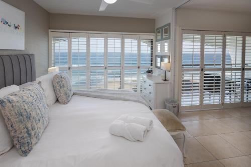 a bedroom with a white bed with a view of the ocean at 504 Bermudas - by Stay in Umhlanga in Durban