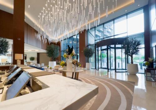 a lobby with a large chandelier in a building at Address Dubai Opera Residences in Dubai