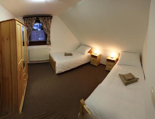 a small room with two beds and a window at Drevenice Zuberec in Zuberec