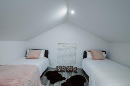 Cette chambre comprend 2 lits et une cheminée en briques. dans l'établissement Loft Near Basel Airport, à Hésingue