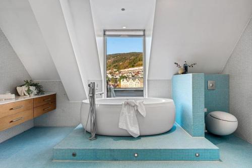 a bathroom with a large tub and a window at Exclusive Penthouse with Terrace in Bergen