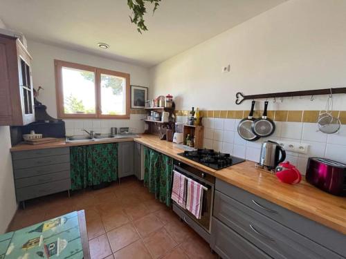 une cuisine avec une cuisinière et un comptoir dans l'établissement Cosy sun-drenched home, 5 min walk to Les Vans, aux Vans