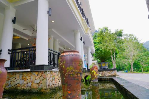 a building with several vases in front of it at Saigon-Ba Be Resort in Ba Be