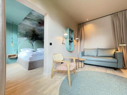 1 dormitorio con cama, sofá y mesa en Romantik Hotel Kieler Kaufmann, en Kiel