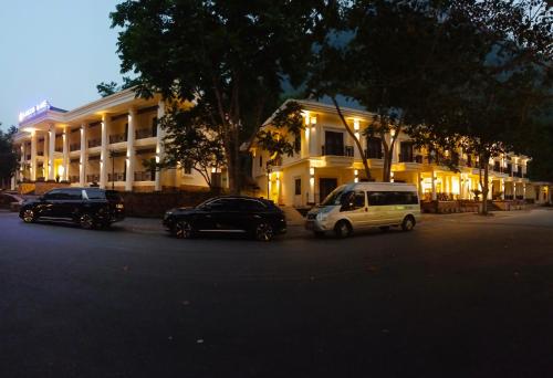 three cars are parked in front of a building at Saigon-Ba Be Resort in Ba Be