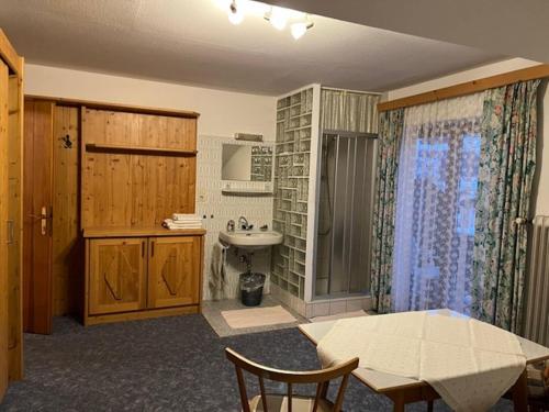 uma casa de banho com uma mesa, um lavatório, uma mesa e cadeiras em Spacious holiday home in Niedernsill em Niedernsill
