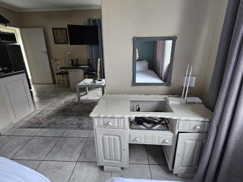 a white bathroom with a sink and a mirror at Senelle accomodation in Hermanus