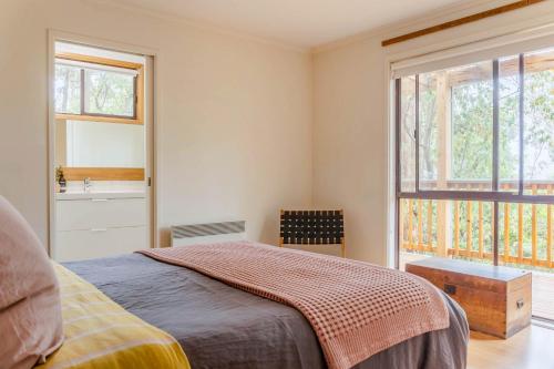 a bedroom with a bed and a window and a sink at Fern House in Wye River