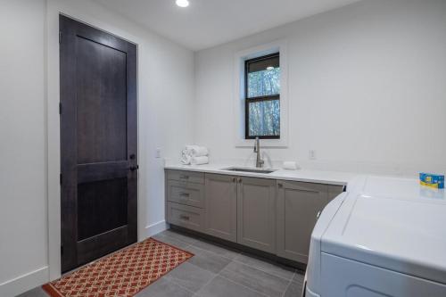 a kitchen with a sink and a window and a door at Suncadia 7 Bdrm Home with Amazing View and a Hot Tub in Cle Elum