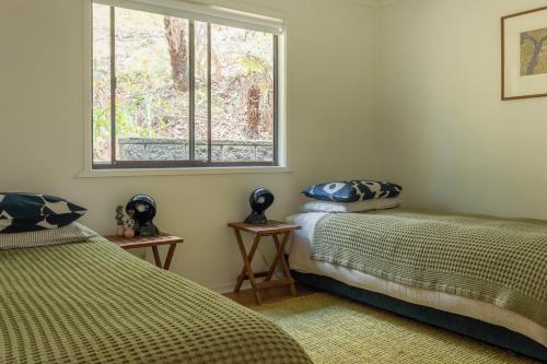2 camas en una habitación con ventana en Fern House, en Wye River